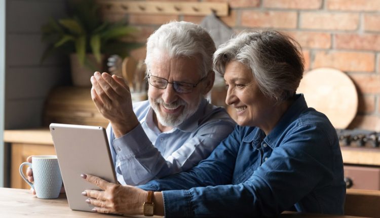 Senior couple watching a movie on a tablet