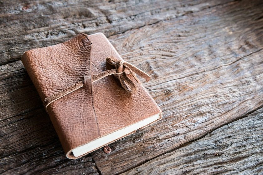 The leather book on the wood table.