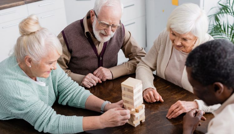 A group of happy seniors playing Jenga