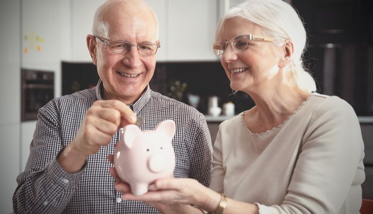 Grandparents are saving money in a piggy bank for grandchildren.