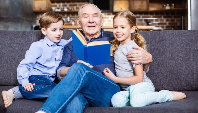 Grandpa reading a book with his grandchildren