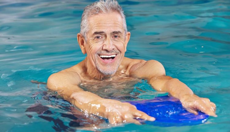 Happy senior man doing aqua yoga in the pool