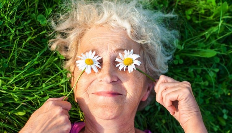 A happy older woman holding flowers in her hands