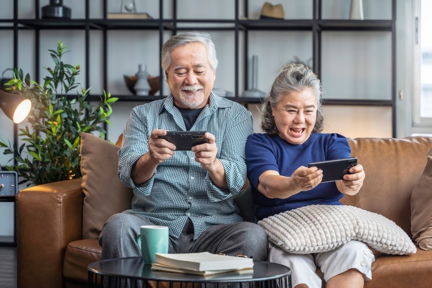 Senior couple playing with their mobile phones.