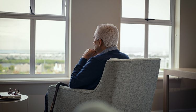 Depressed senior man looking out the window