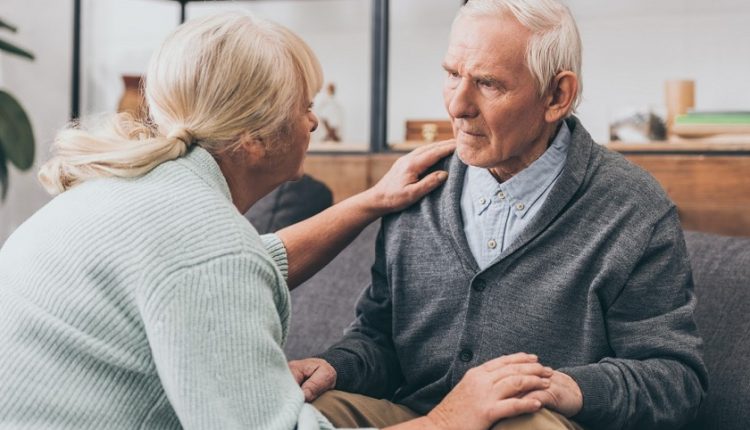 Senior woman reassuring a senior man looking confused