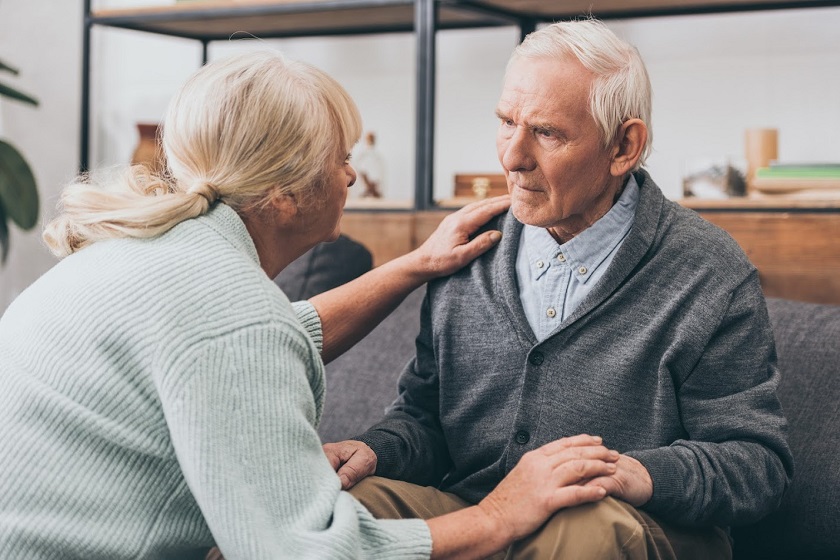 Senior woman reassuring a senior man looking confused