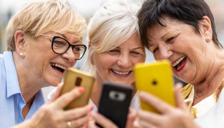 Three senior woman playing with their phones, socializing and having fun.