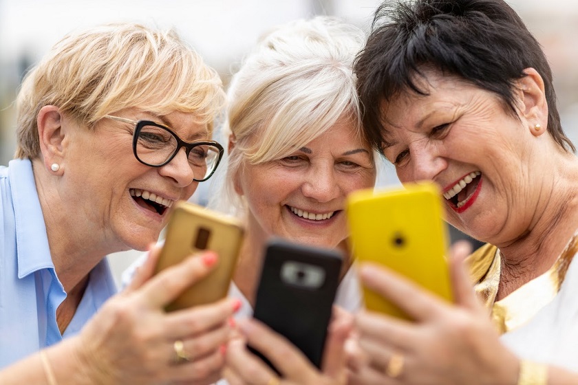 Three senior woman playing with their phones, socializing and having fun.