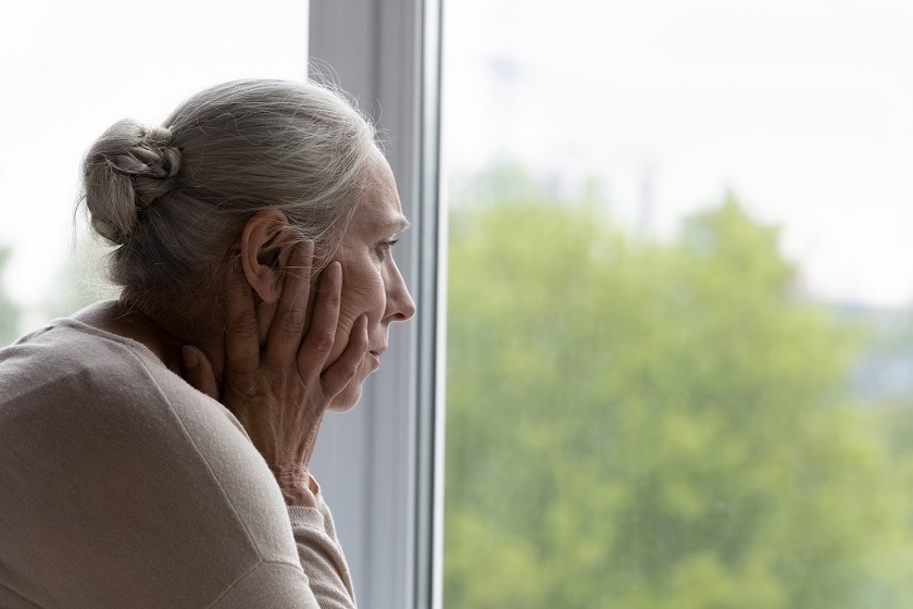 Upset lonely senior lady looking out of window with despair, frustration, going through depression, apathy, mental disorder, thinking over health problems, worried about memory loss, dementia