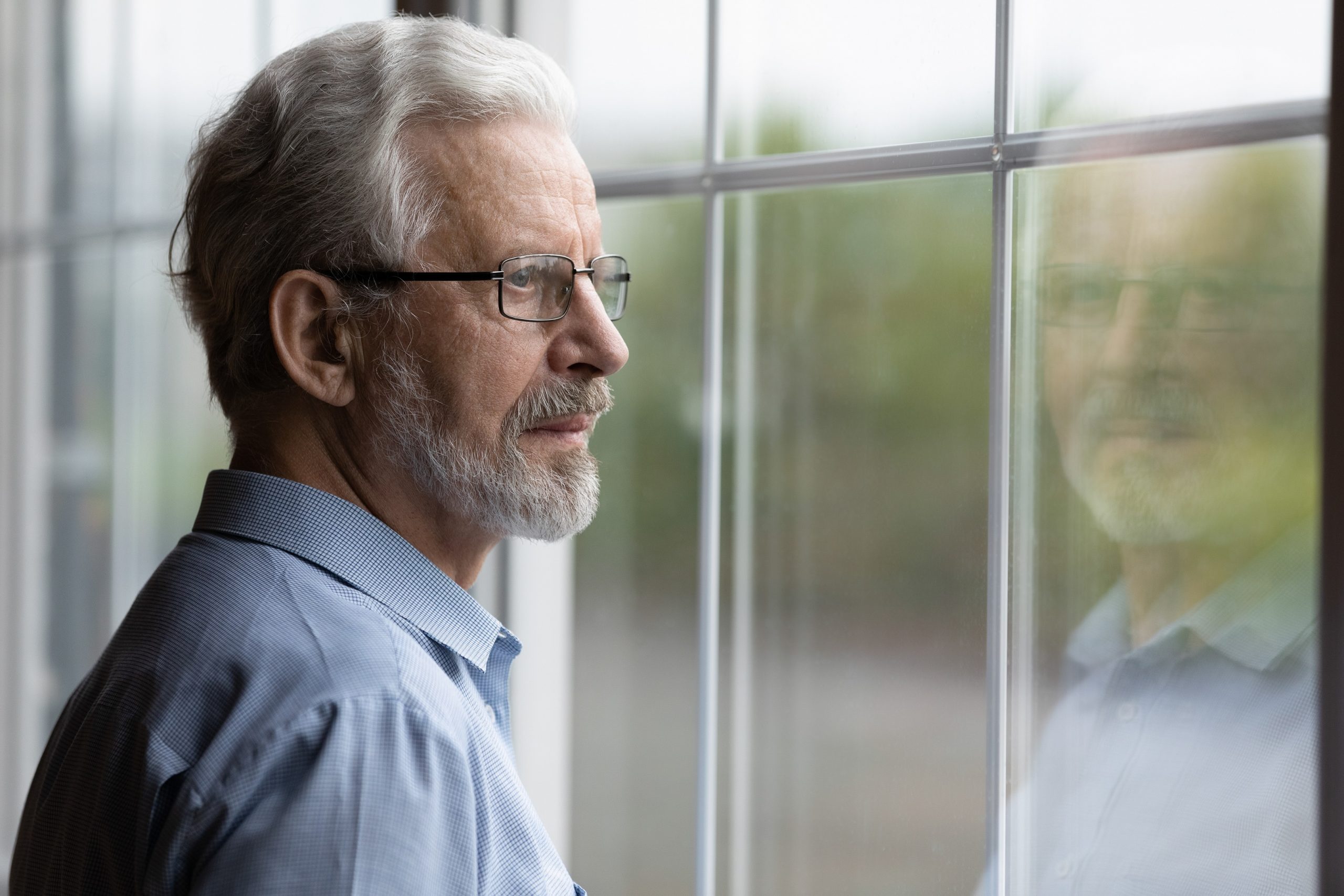 elderly man looking outside the window. Early Alzheimer’s Symptoms