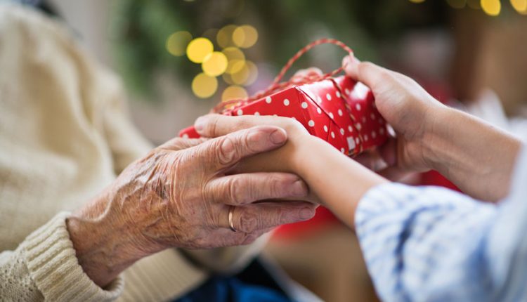 Hands of a senior with Alzheimer's receiving a gift