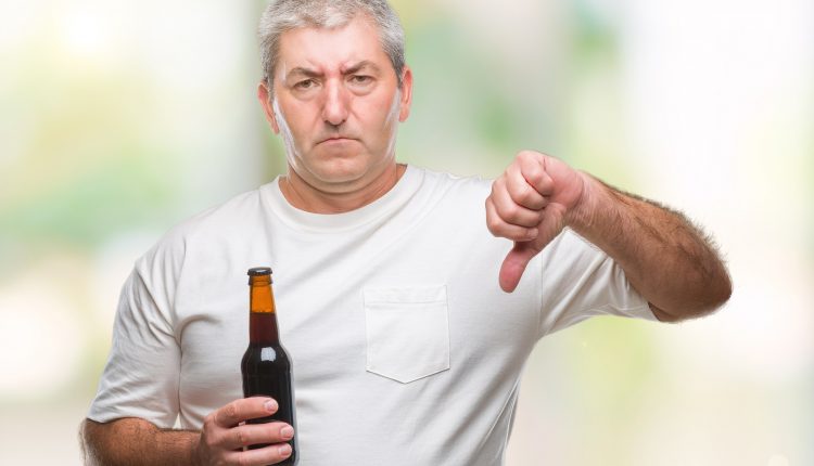 Seniors man holding beer bottle, alcohol related dementia