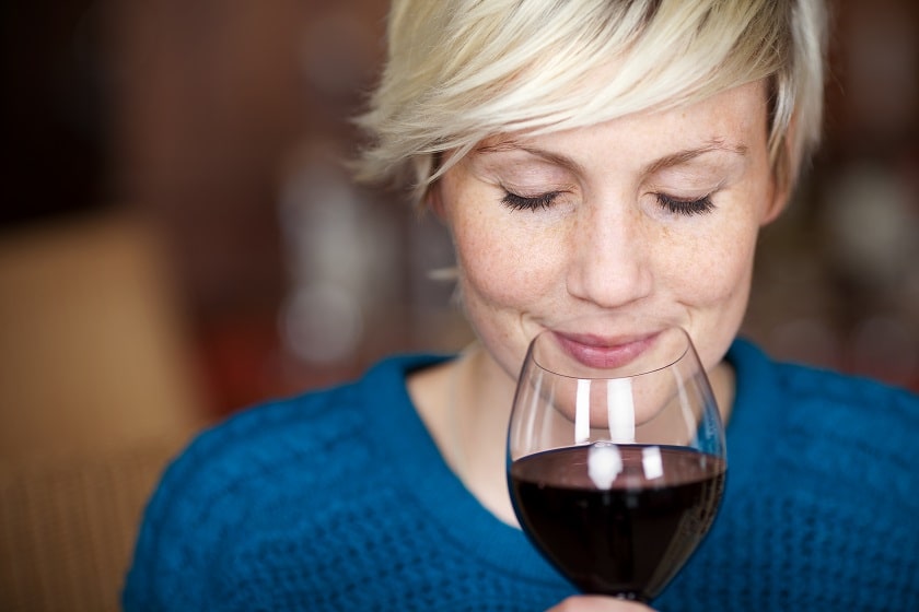 a woman smelling a glass of wine