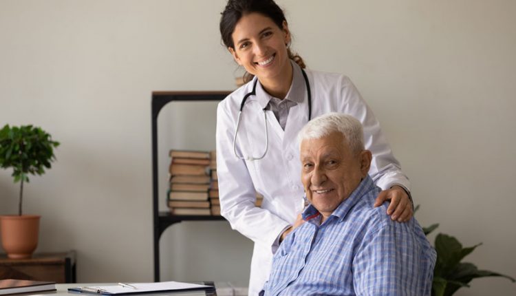 A doctor and Alzheimer's patient looking at the camera and smiling