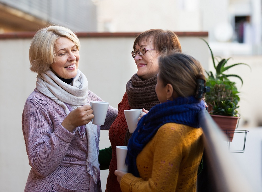 Portrait of happy female pensioners drinking a hot beverage 