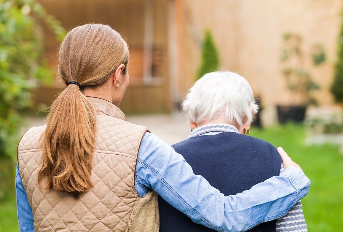 Young carer walking with the elderly woman in the park, Mixed dementia