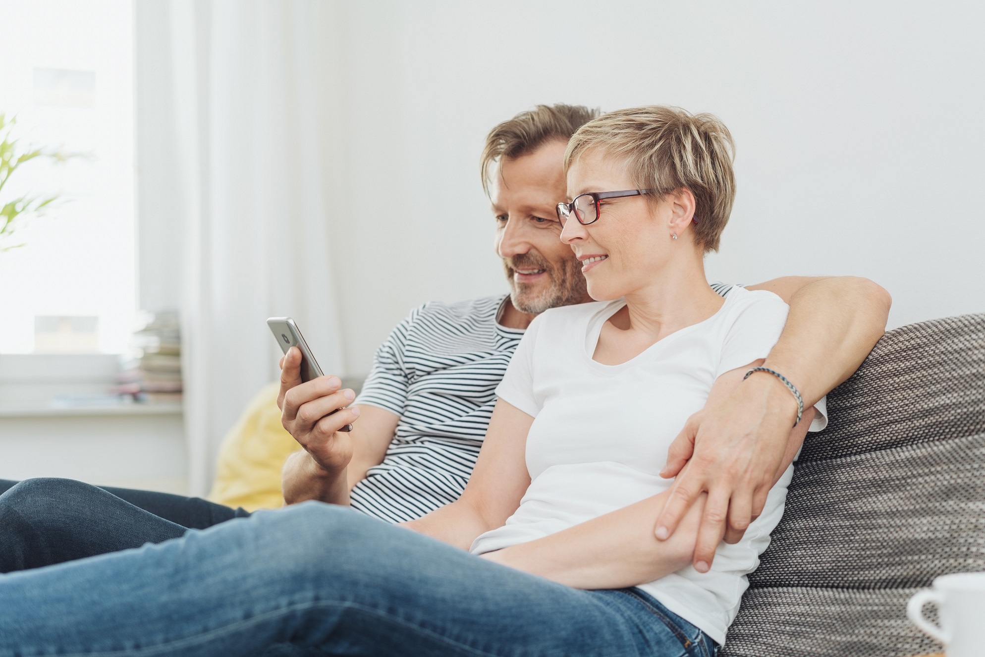 Middle-aged,Couple,Relaxing,On,The,Sofa,At,Home,Looking,At
