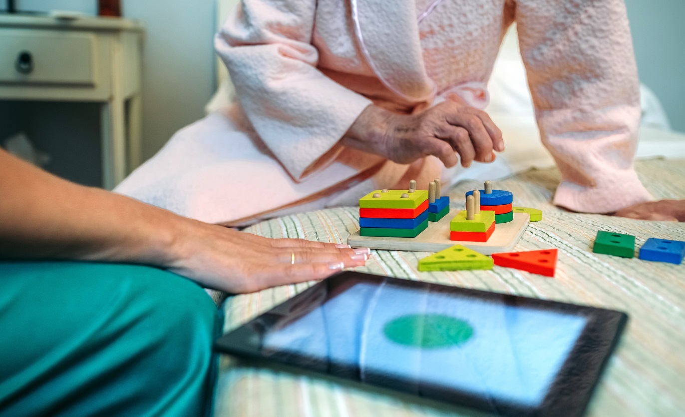 Female,Doctor,Showing,Geometric,Shape,Game,To,Elderly,Female,Patient