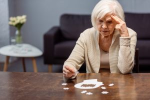 Thoughtful,Senior,Woman,Collecting,Jigsaw,Puzzle,As,Dementia,Therapy