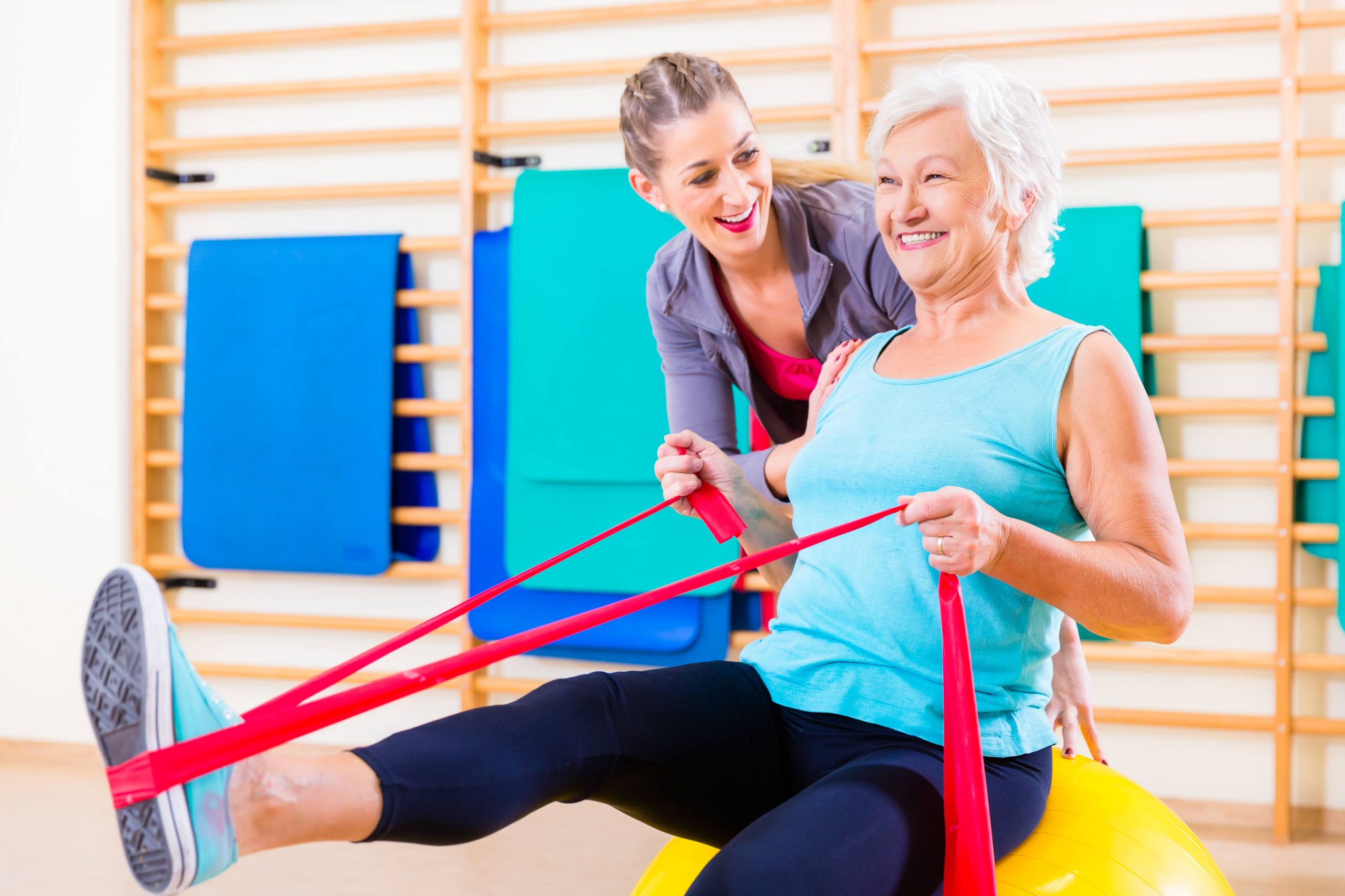 Senior woman doing exercise with a young coach 