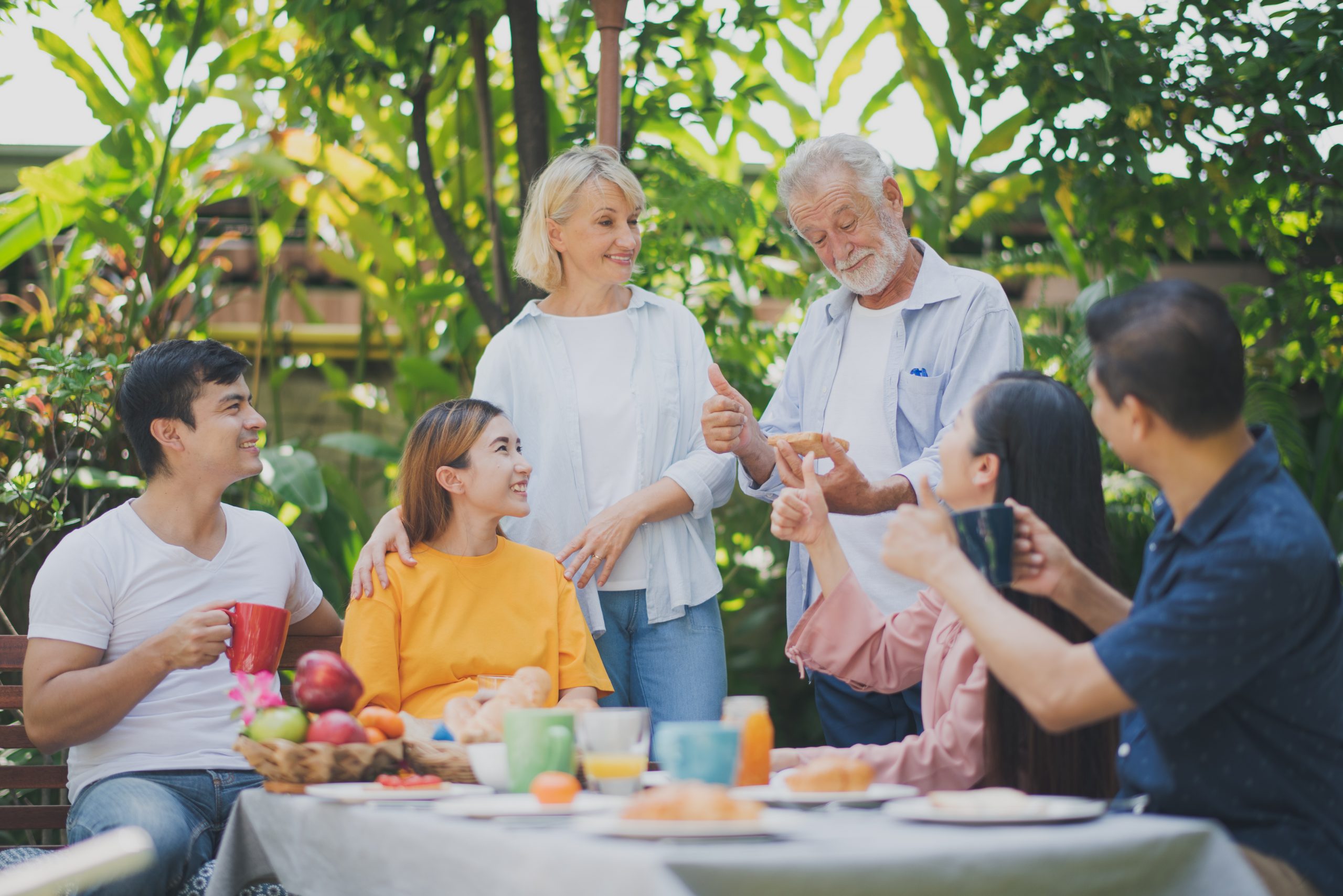 Group of happy people at the table in yard