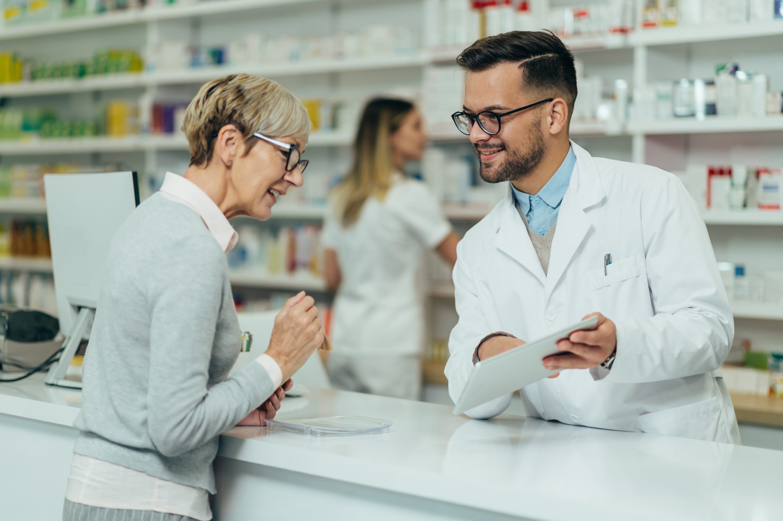 Senior woman talking to pharmacist in pharmacy