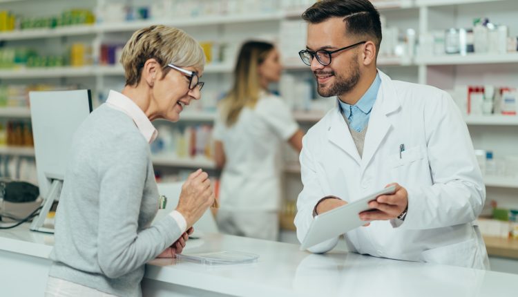 Senior woman talking to pharmacist in pharmacy