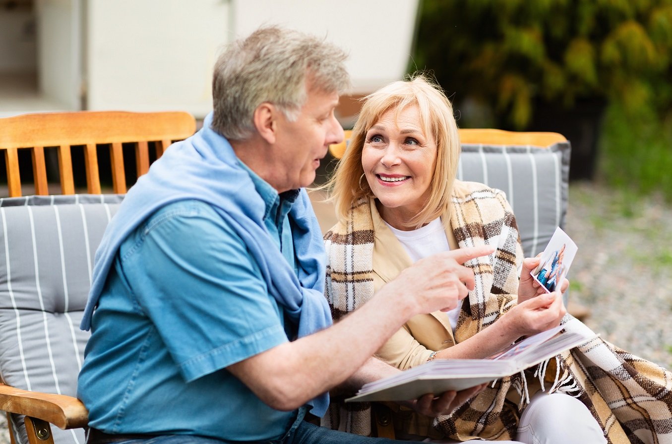 Happy,Memories.,Elderly,Couple,Looking,Through,Family,Photo,Album,Near